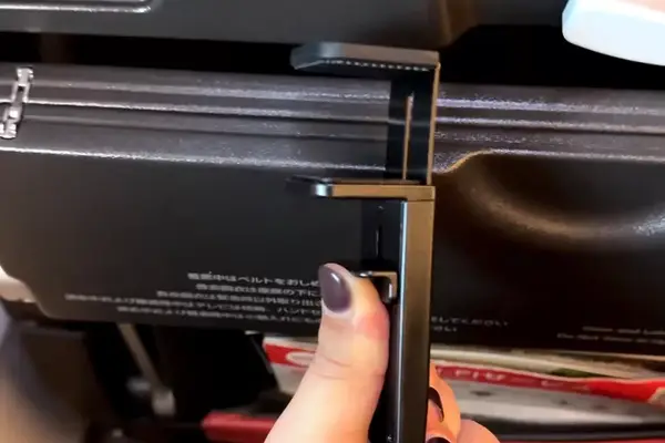 a person placing the Perilogics Universal In-flight Plane Holder Mount on a plane
