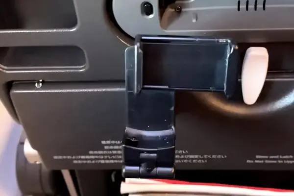 The Perilogics Universal In-flight Plane Holder Mount in the tray table of a planae