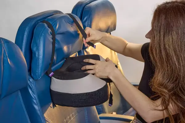 A person strapping the Cabeau The Neck