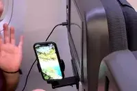 A phone in the Perilogics Universal In-flight Plane Holder Mount on a plane