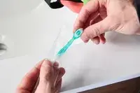 A person removing the Freshee 5-in-1 Disposable Mini Toothbrush from its packaging