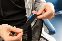 A person undoing the velcro strap on the Ostrichpillow eye mask