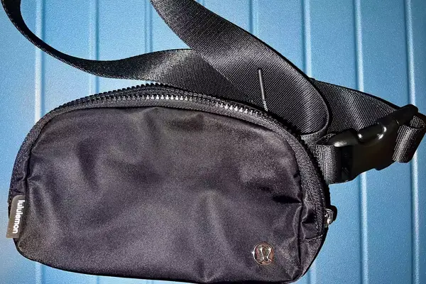 Black lululemon Everywhere Belt Bag against blue background