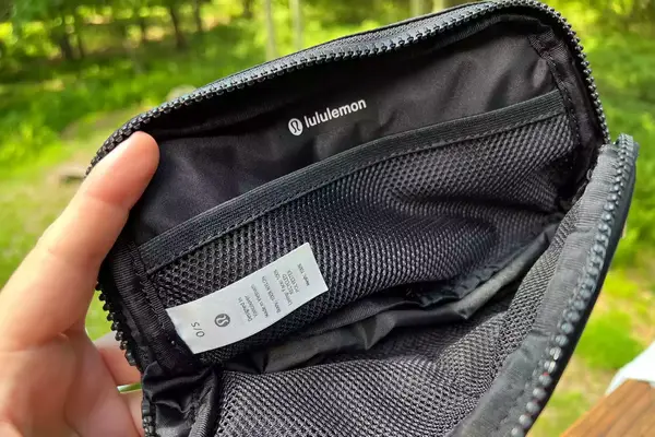 Hand holds open lululemon Everywhere Belt Bag to show inside mesh pockets
