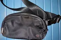 Black lululemon Everywhere Belt Bag against blue background