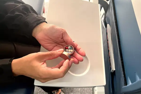 A person opening the PPFISH Portable Daily Pill Case