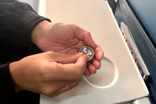 A person taking a pill out of the PPFISH Portable Daily Pill Case