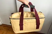 A person carries the Snow Peak Soft Cooler 38 by the top handles