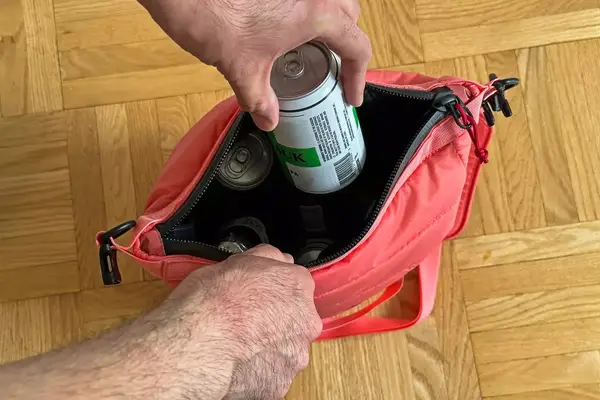 A person places a can into the Monti The Mayfly 14L Cooler