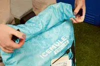 A person removes a can of soda from the Stanley The All Day Julienne Max 30-Can Cooler