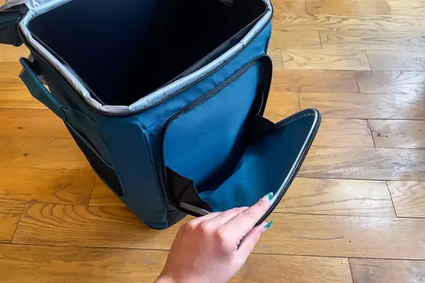 A person holds open a pocket on the Coleman Chiller 42-Can Soft-Sided Portable Cooler with Wheels