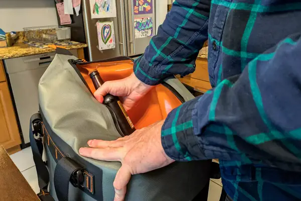 A person packs drinks into the Engel HD30 Heavy-Duty Soft-Sided Cooler Bag
