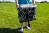A person carries the Engel HD30 Heavy-Duty Soft-Sided Cooler Bag by the side handles