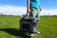 A person carries the Engel HD30 Heavy-Duty Soft-Sided Cooler Bag by the top handles