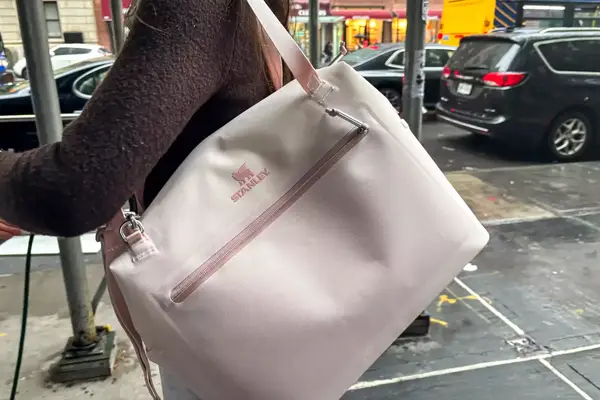 A person carries the Stanley The All Day Julienne Max 30-Can Cooler by the shoulder strap