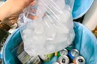 A bag of ice is placed into the Hydro Flask 20L Carry Out Soft Cooler Travel Bag