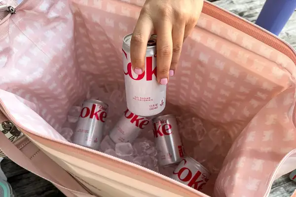 A person removes a can of soda from the Stanley The All Day Julienne Max 30-Can Cooler