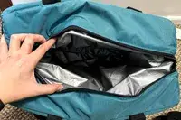 A person holds the Igloo Latitude Snapdown 36-Can Cooler Bag open