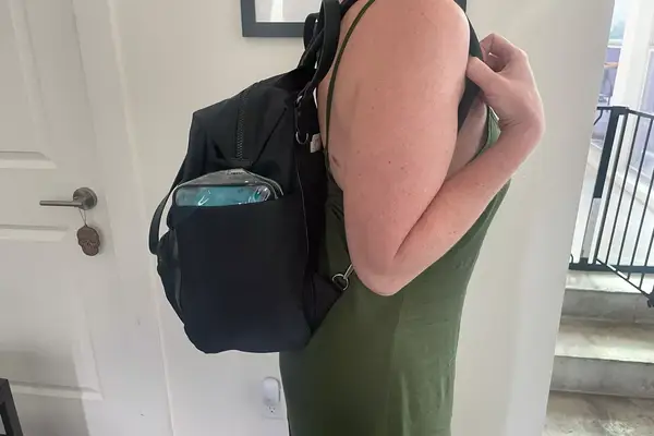 A person wears the Baggallini Nolita Convertible Backpack