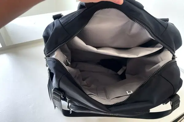A person shoes the inside of the Baggallini Nolita Convertible Backpack