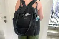 A person wears the Baggallini Nolita Convertible Backpack