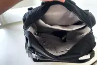 A person shoes the inside of the Baggallini Nolita Convertible Backpack