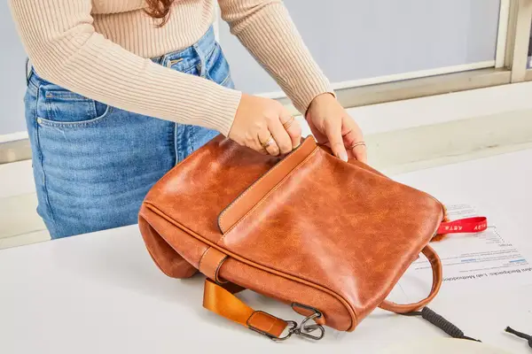 A person places the L.L.Bean Stowaway Day Pack in the seat in front of them