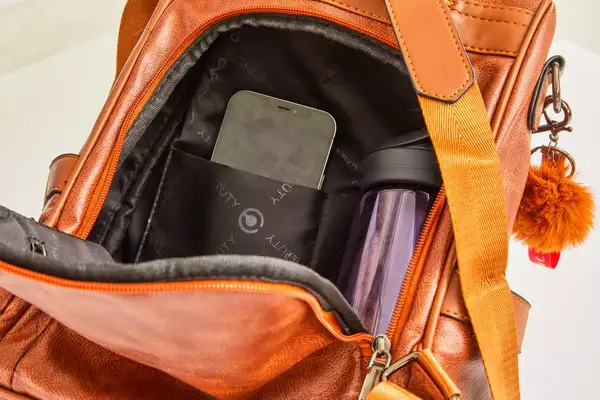 A person tightens the straps on the front of the L.L.Bean Stowaway Day Pack