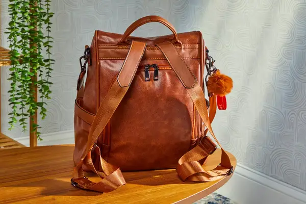 A person places the L.L.Bean Stowaway Day Pack into an overhead compartment