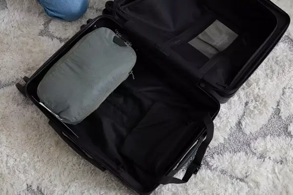 A person packing a Patagonia Black Hole Cube on a couch