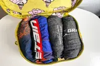 A close-up of a filled piece of the Baggu Packing Cube Set on a white table