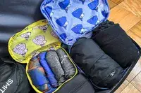 A close-up of the Baggu Packing Cube Set opened in a suitcase