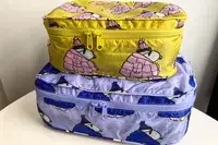 A filled Baggu Packing Cube Set on a white table