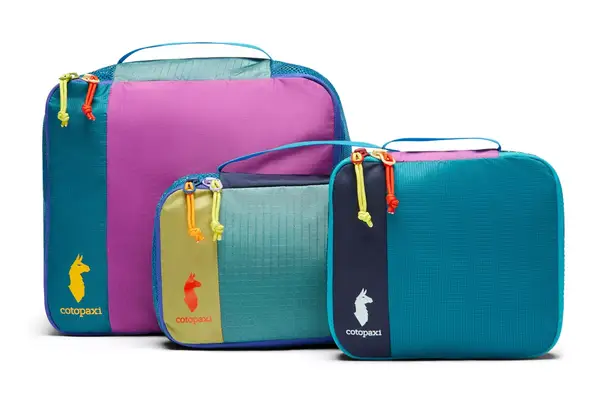 A person packing a Patagonia Black Hole Cube on a couch