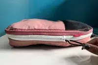 A hand touching the zipper of a Blast 6PCS Compression Travel Packing Cubes cube