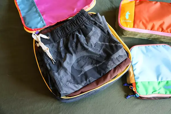 An opened Cotopaxi Cubos Packing Cube next to closed cubes