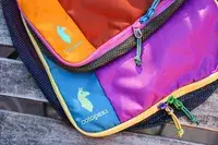 A close-up of two closed Cotopaxi Cubos Packing Cubes on a wooden surface