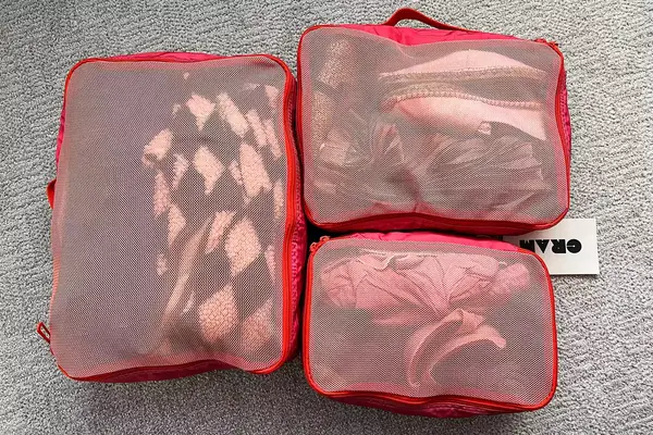 The Cram Packing Cubes filled wiht items while placed on a carpet