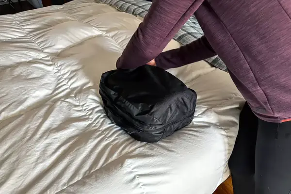 A person closing the Patagonia Black Hole Cube, Large 14L