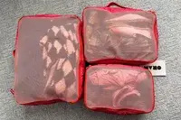 The Cram Packing Cubes filled wiht items while placed on a carpet