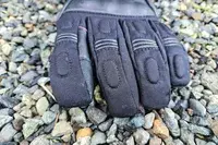 The Gerbing 7V Hard Knuckle Battery Heated Gloves on gravel