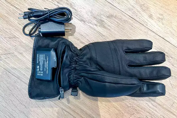 DAY WOLF Rechargeable electric gloves on a wooden floor with a charging adapter