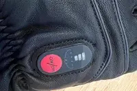 A close-up of the power button on the DAY WOLF Rechargeable electric gloves