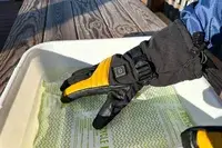 A person wears the Gobi Heat ​​Vertex II Heated Ski Gloves outside