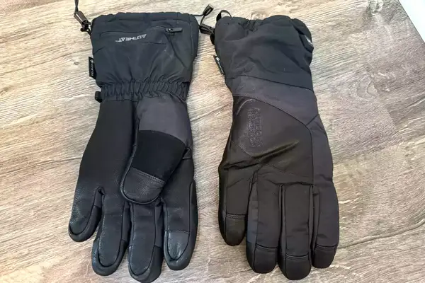 The Outdoor Research Prevail Heated GORE-TEX Gloves on a wooden floor