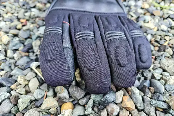 The Gerbing 7V Hard Knuckle Battery Heated Gloves on gravel