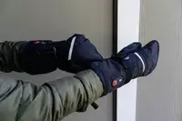 A person pulls the Snow Deer Heated Mittens on