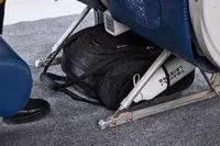 The Rockland Melrose Upright Wheeled Underseater Luggage under an airplane seat