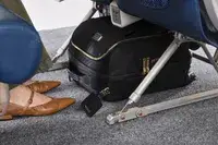 The Tumi Voyageur Léger Compact Carry-on under an airplane seat