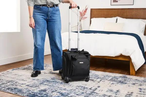 A person wheels the Samsonite Theorym Underseater over a carpet